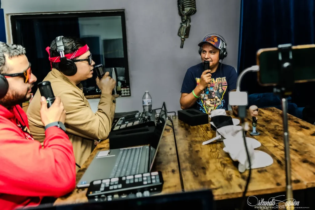 Misa and Chuy interviewing a guest around the studio table