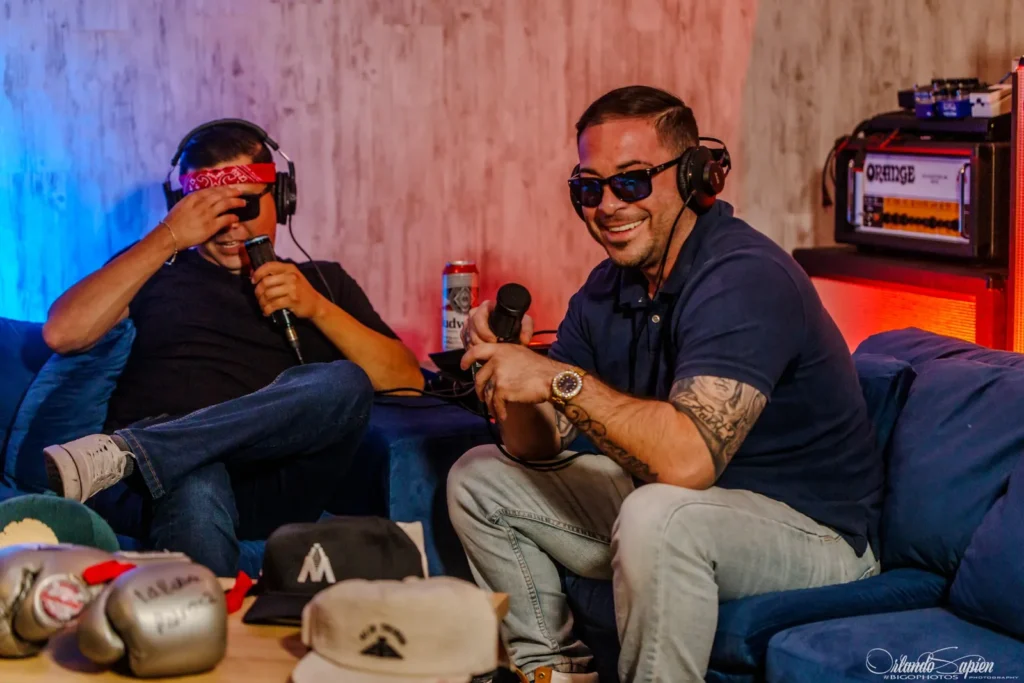 Host sharing a laugh with a guest on the studio couch